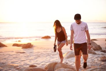 Couple of friends, sunset and walk at ocean for journey,...