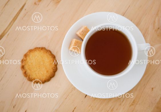 Cup of black tea, sugar and biscuits