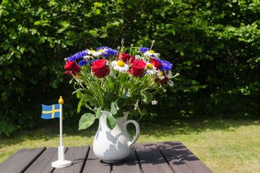 Bukett sommarblommor på ett bord i trädgården