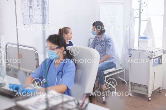 Therapeutist assistant writing treatment on laptop...