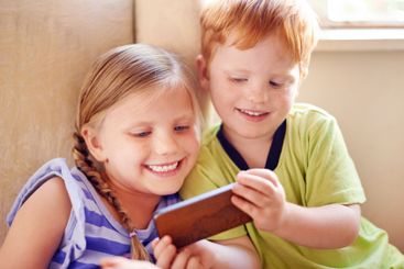 Fun, siblings and children with smartphone, watching and...