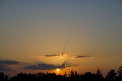Sky illuminated by orange, yellow and pink afterglow