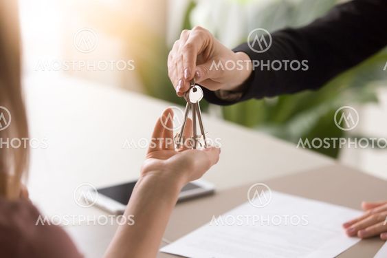 Woman getting keys to new rented own apartment, close up