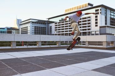 Skateboard, city and man with ollie flip in air for jump...