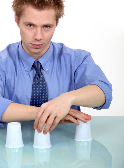 Man performing trick with three cups