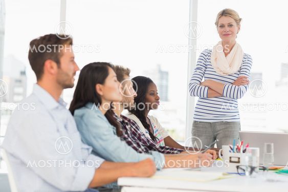 Happy team of young designers listening at meeting
