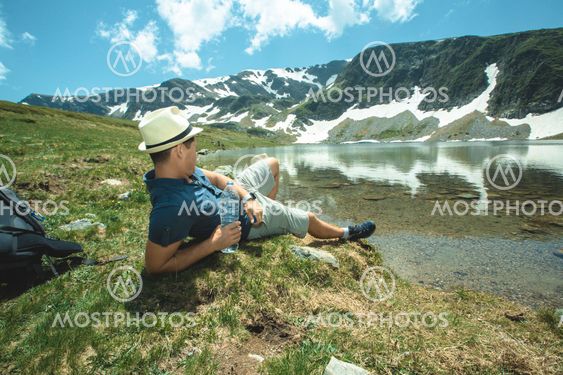 Traveler Man relaxing near the mountain lake