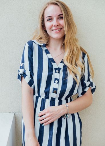 Beautiful fashionable woman in summer striped dress smiling