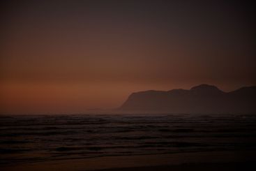 Sunset, mountains and beach with waves, sky and tropical...