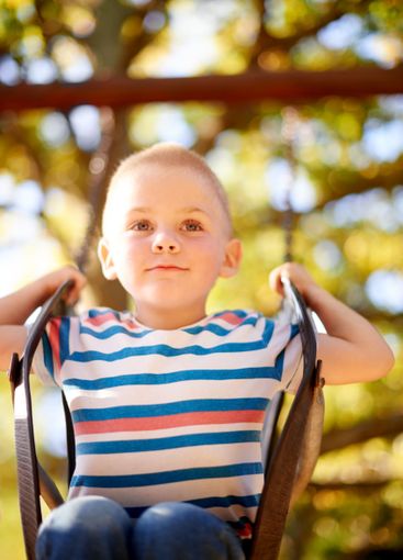 Fun, swing and kid in park with trees, outdoor adventure...