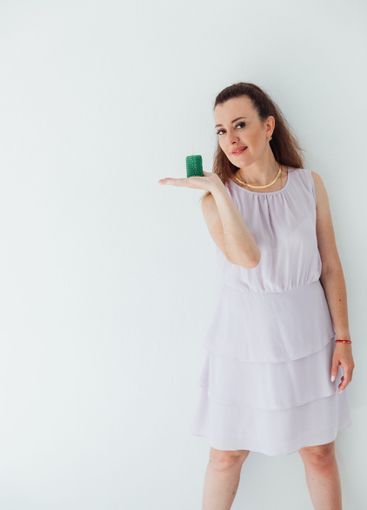 Beautiful brunette woman holding a green candle in her...