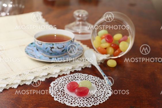 Tea with coloured sugar candies in a glass can