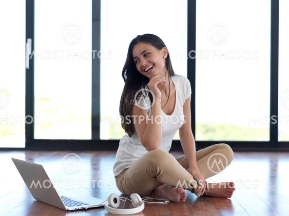 relaxed young woman at home working on laptop computer