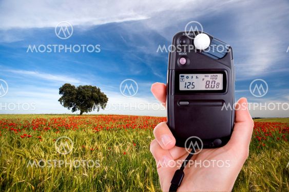 photographer using lightmeter to measure light in landscape