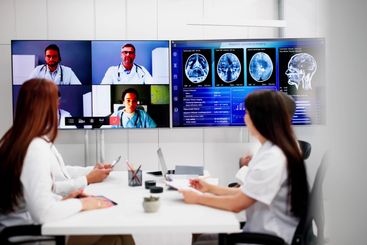 Doctors In Clinic Looking At Brain MRI Scan
