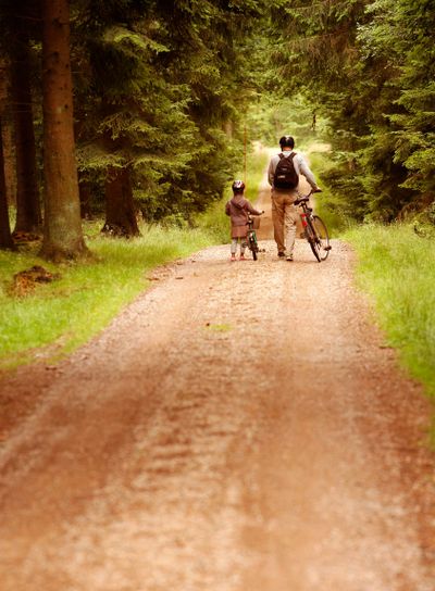 Vuxen och barn på skogsväg