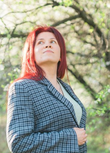 Beautiful young red hair woman near blooming spring...