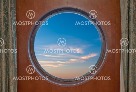 Blue sky seen through the porthole of a ship