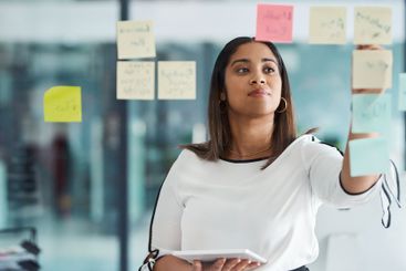 Glass wall, planning and businesswoman in office with...