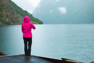 Tourist looking at mountains and fjord Norway, Scandinavia.
