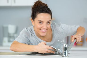 female trainee plumber working on tap
