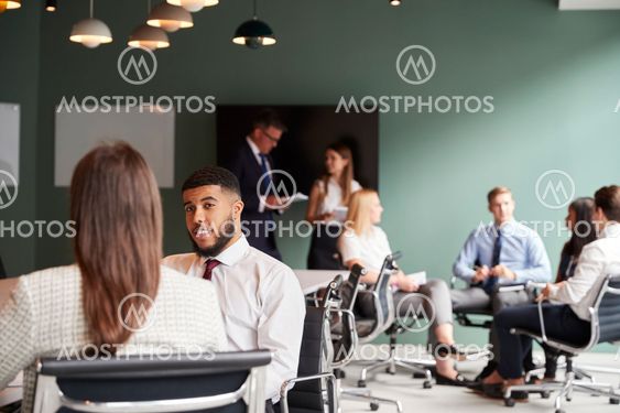 Businesswoman And Businessman Collaborating On Task...