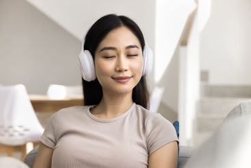 Close up serene Chinese woman relish favourite music