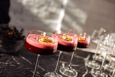 Pink sweet and sour berry cocktails with fluffy foam in...