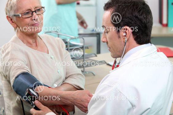 Doctor checking the blood pressure of an elderly lady