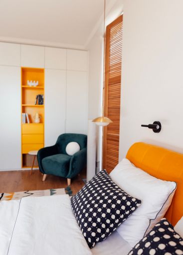 A modern bedroom with a comfortable bed and a bright...