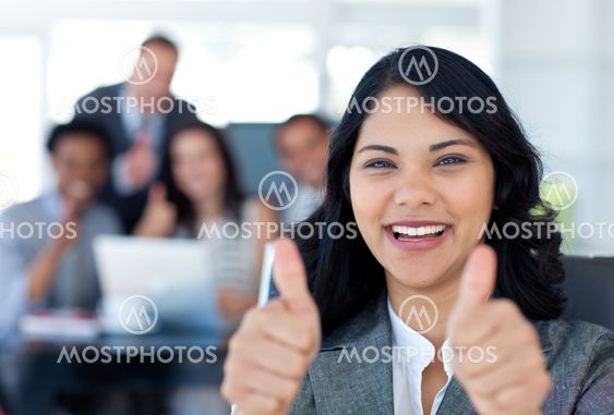 Portrait of a businesswoman with thumbs up in office