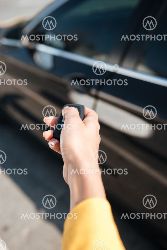 Woman hand holding keys and closing door of her car