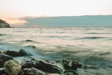 Serene coastal landscape at dusk with smooth waves...