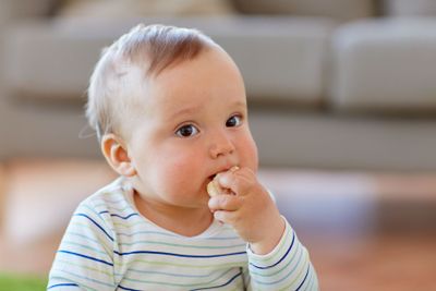 baby boy eating rice cracker at home