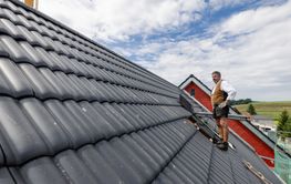 roofer working with tiles on the roof.