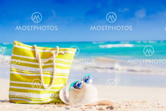 beach bag, sunglasses and straw hat on tropical beach