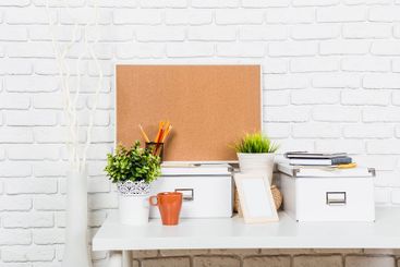Decorative workspace setup featuring corkboard, plants,...