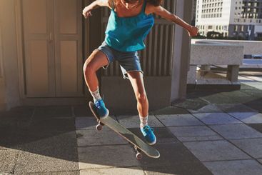 Skateboard, city and woman with flip in air for jump...