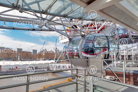 London, UK - April 2018: Ovoidal passenger capsule arriving at boarding platform of the London Eye, a popular giant Ferris wheel, iconic landmark of London, located on the South Bank of River Thames in London, England