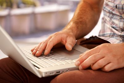 Closeup photo of male hands typing on laptop�