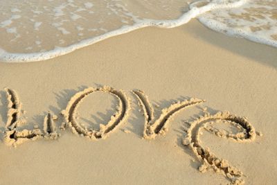 Inscription "love" on sand