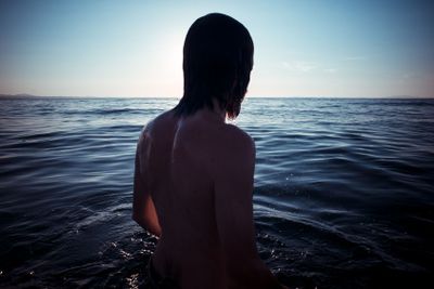 man back to the sea at sunset