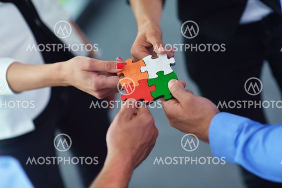 Group of business people assembling jigsaw puzzle