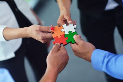 Group of business people assembling jigsaw puzzle