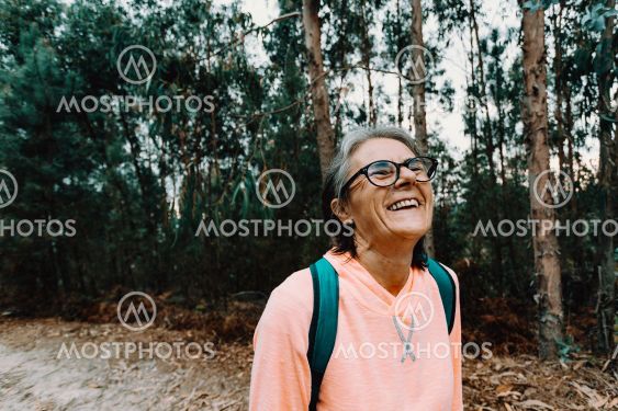 Old woman laughing in the middle of the forest in spain...