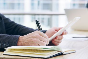 Tablet, notebook and research with hands of employee in...