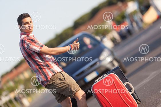 Young Man Hitchhiking along the Road