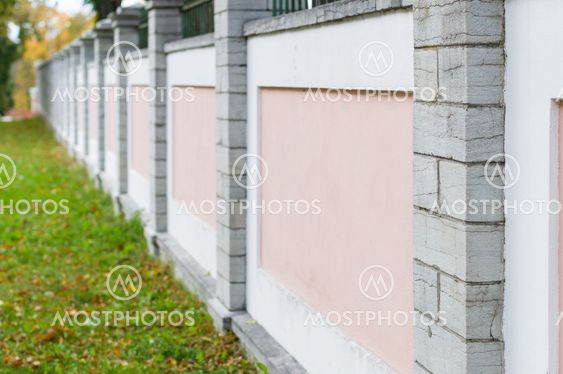 Pink and white concrete fence with stone columns