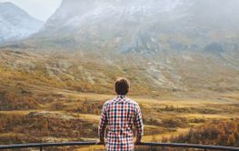 Traveler man in mountains of Norway autumn season travel