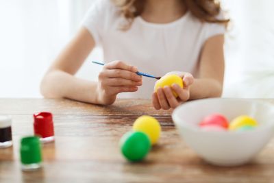 close up of girl coloring eggs for easter